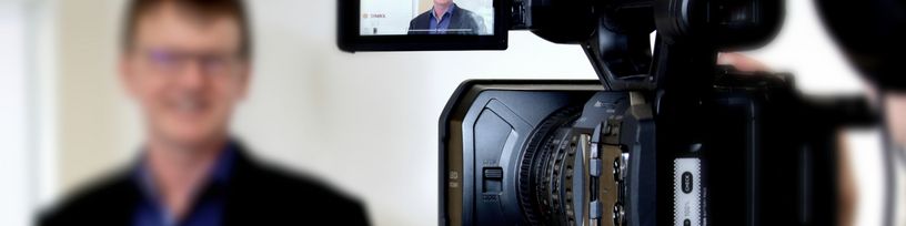 Eine Videokamera filmt einen Referenten