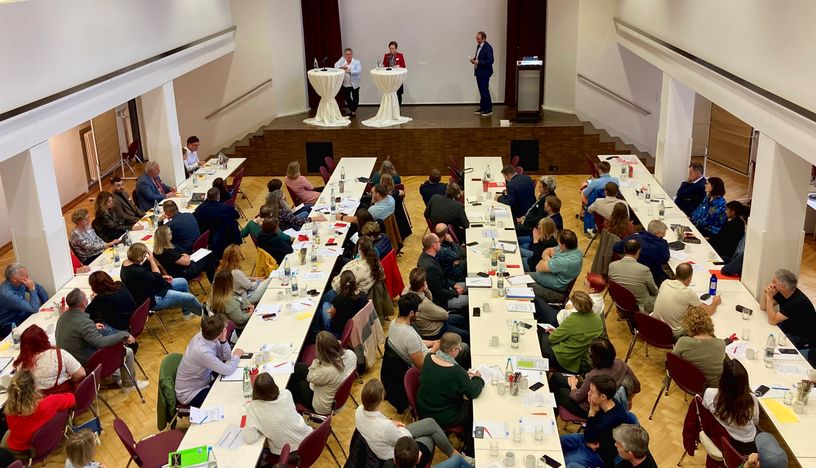 Das Publikum im großen Saal des Kolpinghauses blickt zu den Referentinnen auf der Bühne.